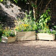 Gresford Planter Set next to a wall in garden